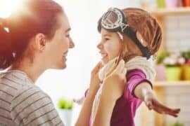 mom smiling at special needs child dressed like superhero