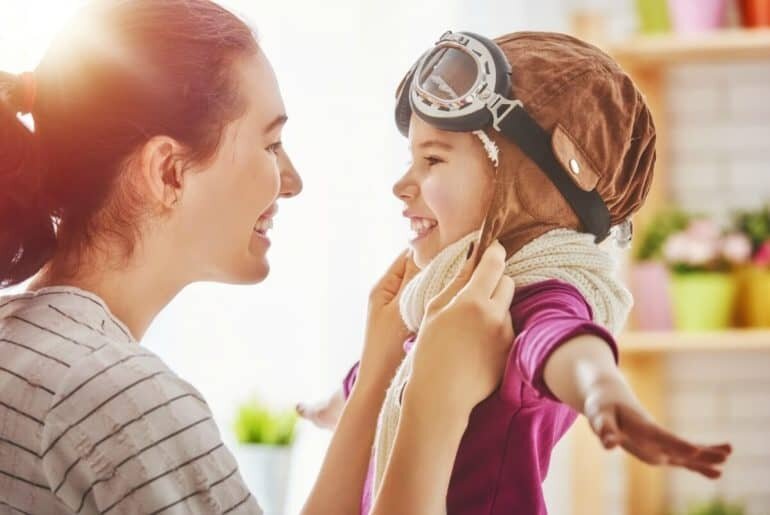 mom smiling at special needs child dressed like superhero